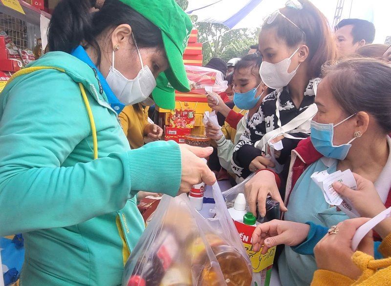 Các công nhân lao động mua hàng từ phiếu mua hàng do Công đoàn các Khu chế xuất & công nghiệp TPHCM trao tặng. Ảnh: Nam Dương 