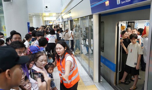 Nhân viên ga Bến Thành hướng dẫn hành khách đi Metro số 1.  Ảnh: Anh Tú