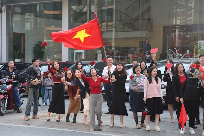 15h15, nhiều nhân viên văn phòng ở khu vực đường Nghi Tàm (Tây Hồ, Hà Nội) cũng xuống đường cầm cờ hoa chào đón các cầu thủ. Ảnh: Việt Anh. 