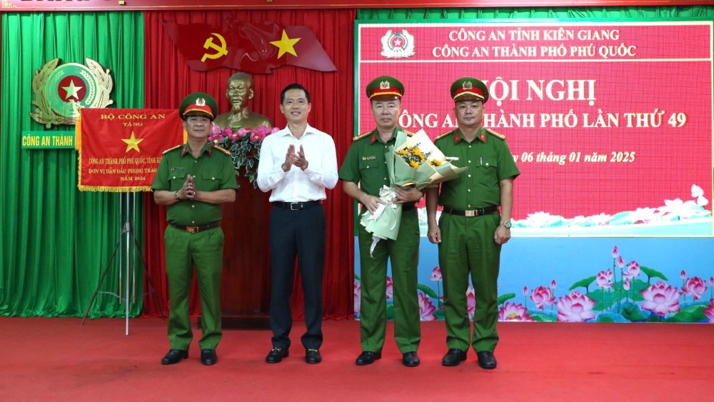 ÔngTrần Minh Khoa, Chủ tịch UBND TP Phú Quốc tặng hoa chúc mừng Ban lãnh đạo Công an TP Phú Quốc. Ảnh: Tiến Dũng

