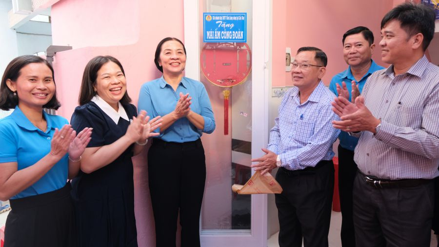 Female member Le Kim Lon (second from left) smiles brightly on the day she moves into her new home. Photo: My Ly