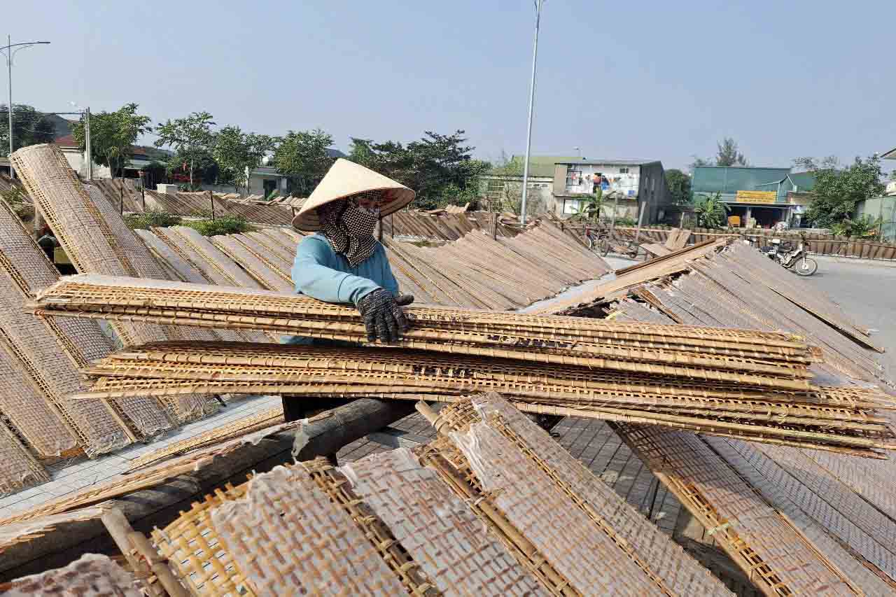 Nguoi phu nu nay duoc chu co so san xuat thue di phoi banh da nem. Anh: Tran Tuan.