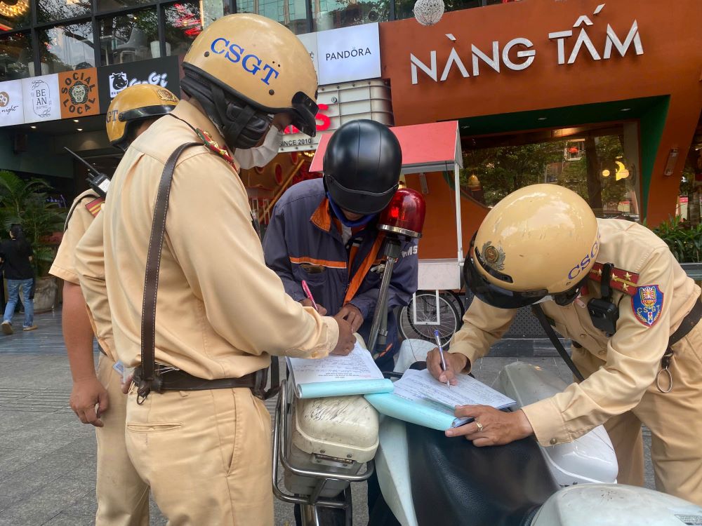 Male delivery man fined by traffic police. Photo: Vien Chinh