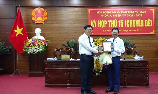 Ủy viên Ban Chấp hành Trung ương Đảng, Bí thư Tỉnh ủy, Chủ tịch HĐND tỉnh Nguyễn Tiến Hải Cà Mau (bên trái) tặng hoa chúc mừng ông Dương Huỳnh Khải nghỉ hưu theo chế độ. Ảnh: UBND tỉnh Cà Mau