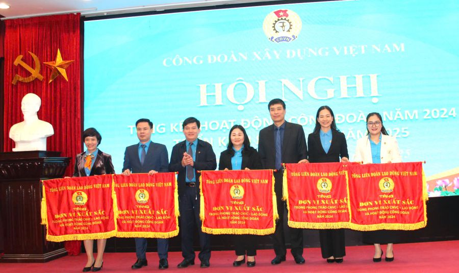 Vice President of the Vietnam General Confederation of Labor Nguyen Xuan Hung (third from left) presents the Emulation Flag of the Vietnam General Confederation of Labor to the collectives. Photo: Bao Han