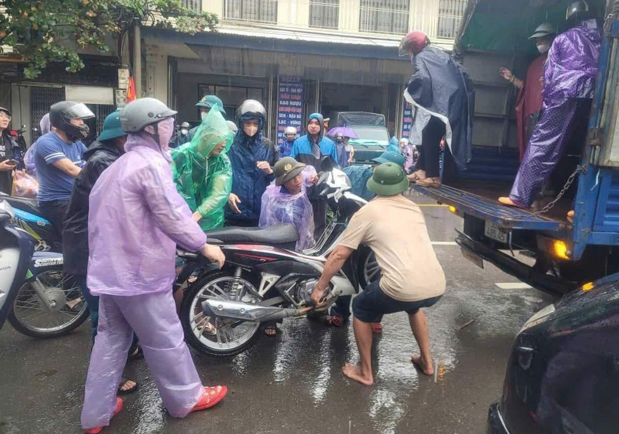 Cac chu xe tai ho tro cho mien phi nguoi dan va phuong tien ca nhan qua diem ngoc lut. Anh: Dieu Anh