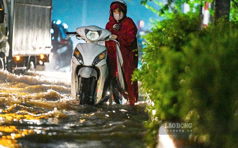 People struggle to bring their vehicles home after yesterday's heavy rain on September 30. Photo: To The