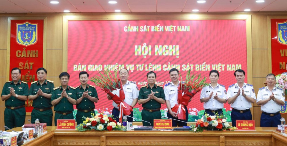 Le general Nguyen Tan Cuong - chef d'etat-major general de l'Armee populaire vietnamienne - vice-ministre de la Defense nationale - offre des fleurs pour feliciter le lieutenant-general Le Quang Dao et le major-general Le Dinh Cuong. Photo : Duc Tinh