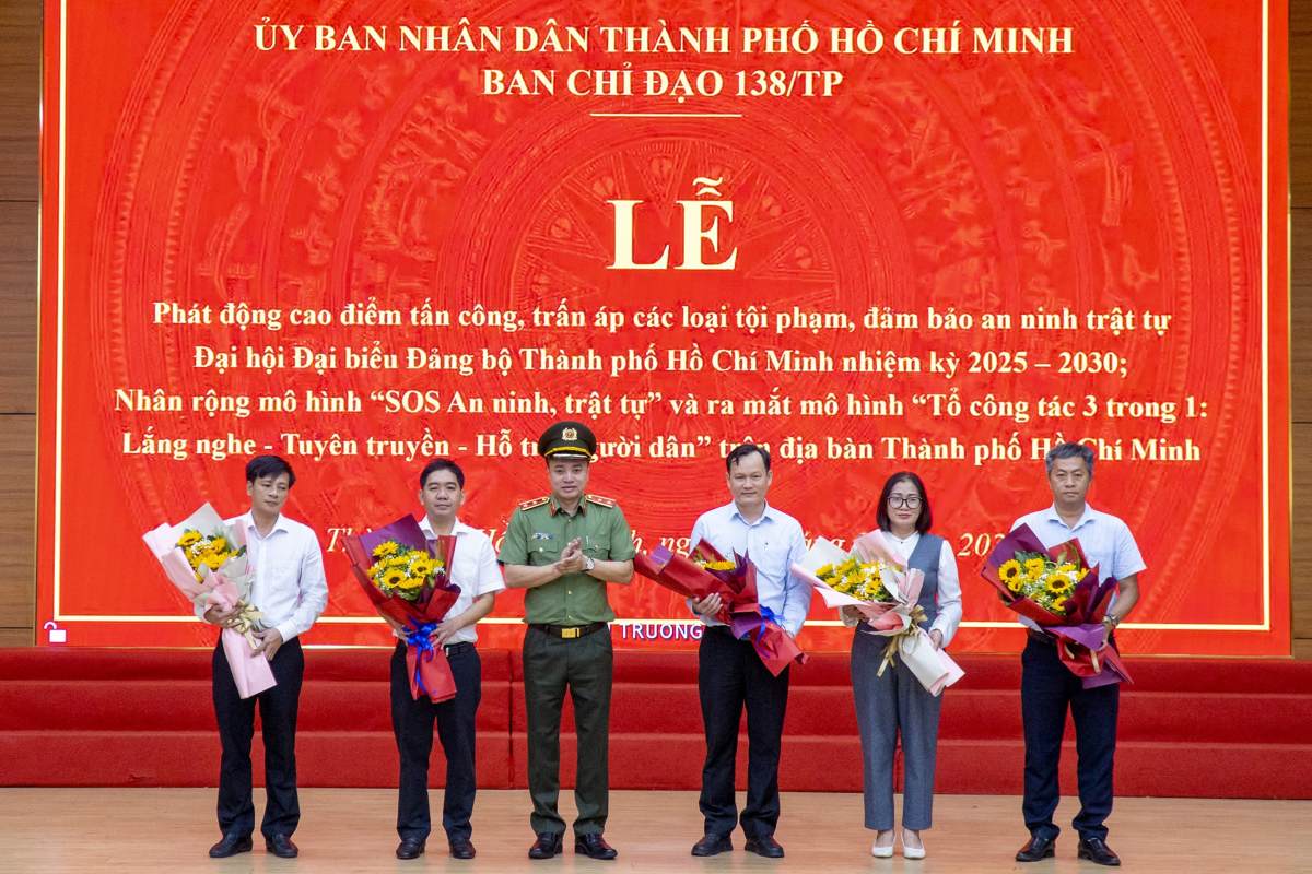 Trung tuong Mai Hoang tang hoa chuc mung dai dien To cong tac 3 trong 1 cua mot so phuong xa. Anh: Manh Thang