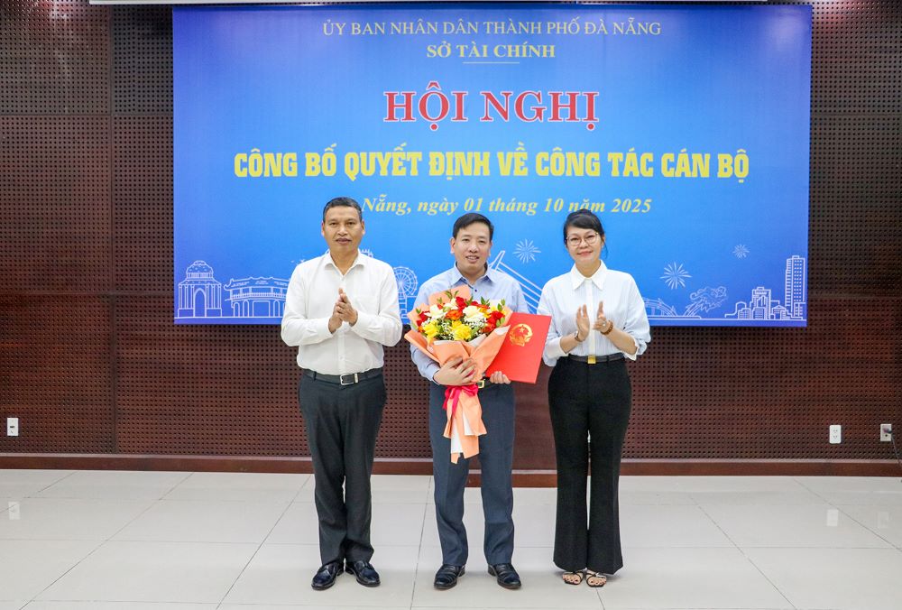 Mr. Ho Ky Minh - Vice Chairman of Da Nang City People's Committee and Director of the Department of Finance presented the decision and presented flowers to congratulate Mr. Nguyen Hoang Ha (middle). Photo: Thanh Thao