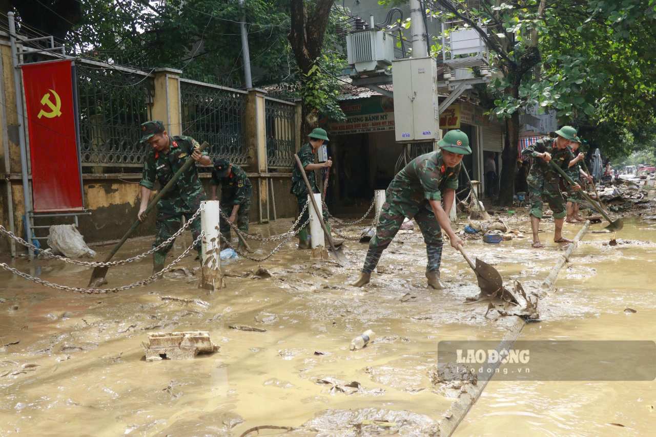 Cac chien si chia lam nhieu to den ho tro nguoi dan don dep nha cua. Anh: Van Duc