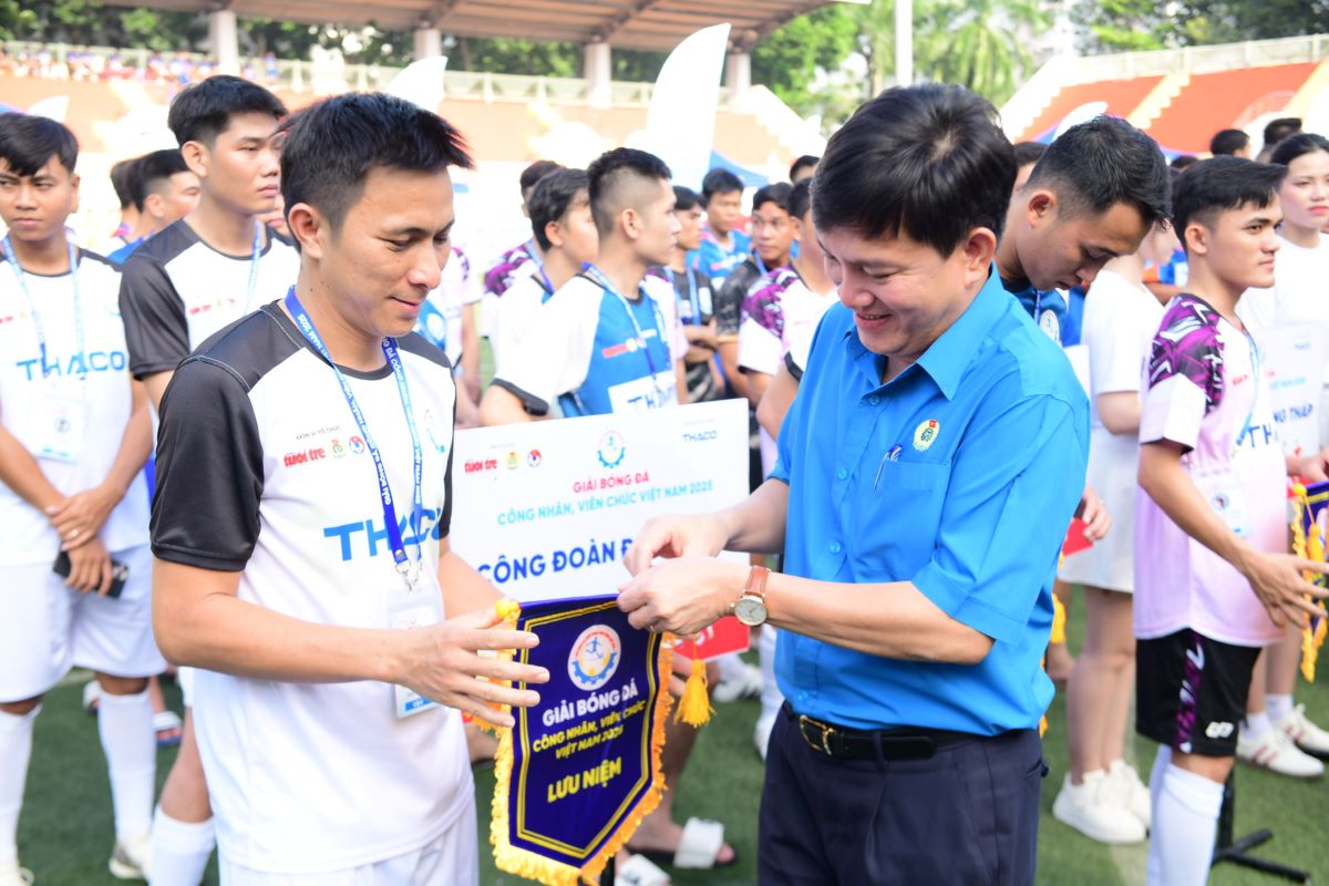 Ong Nguyen Xuan Hung, Pho Chu tich Tong Lien doan Lao Dong Viet Nam trao co luu niem cho cac doi tham du. Anh: Dinh Quang