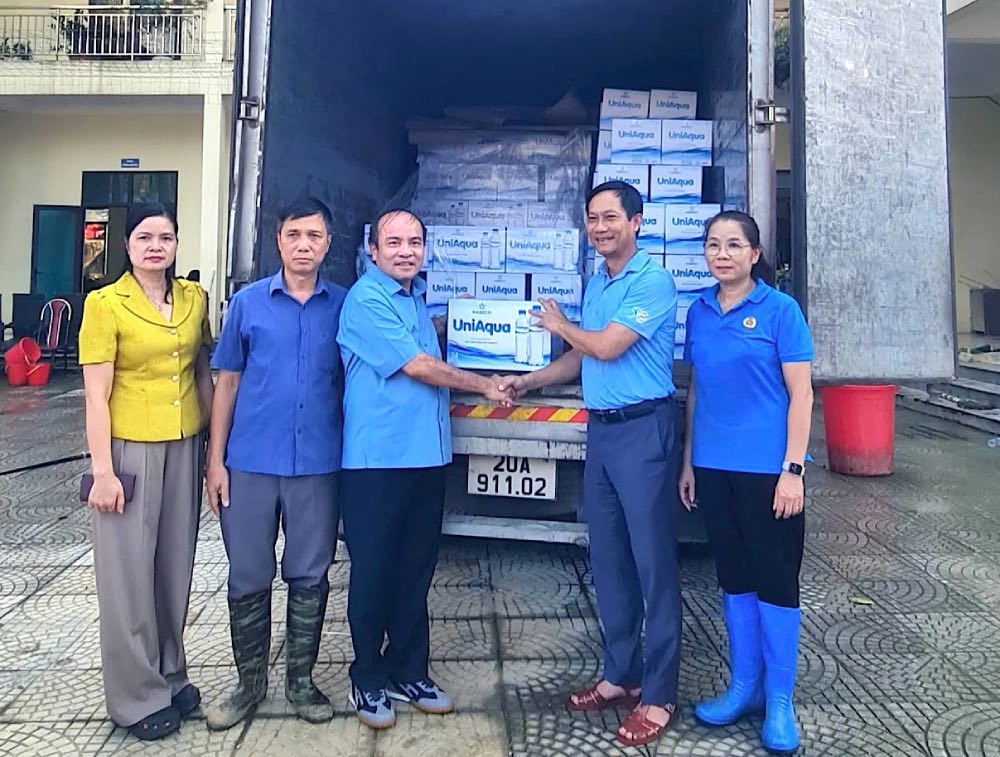 El Sr. Le An Hai Presidente del Sindicato de Industria y Comercio de Vietnam (segundo desde la derecha) entrega apoyo a las unidades afectadas por las tormentas y las inundaciones. Foto: Thanh Thai