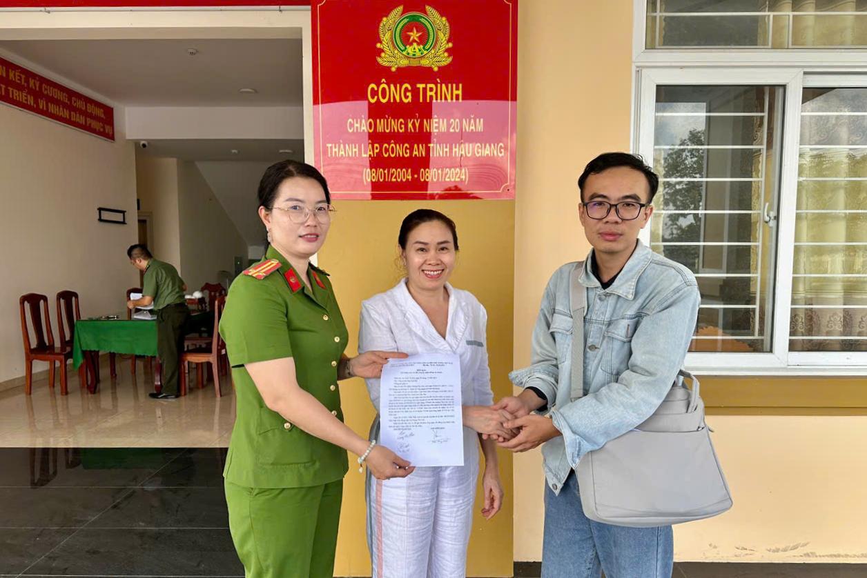 Anh Tran Nhat Anh trao tra so tien 400 trieu dong chuyen nham cho chi Hoang Thi Lien tai Cong an phuong Nga Bay. Anh: Cong an Can Tho