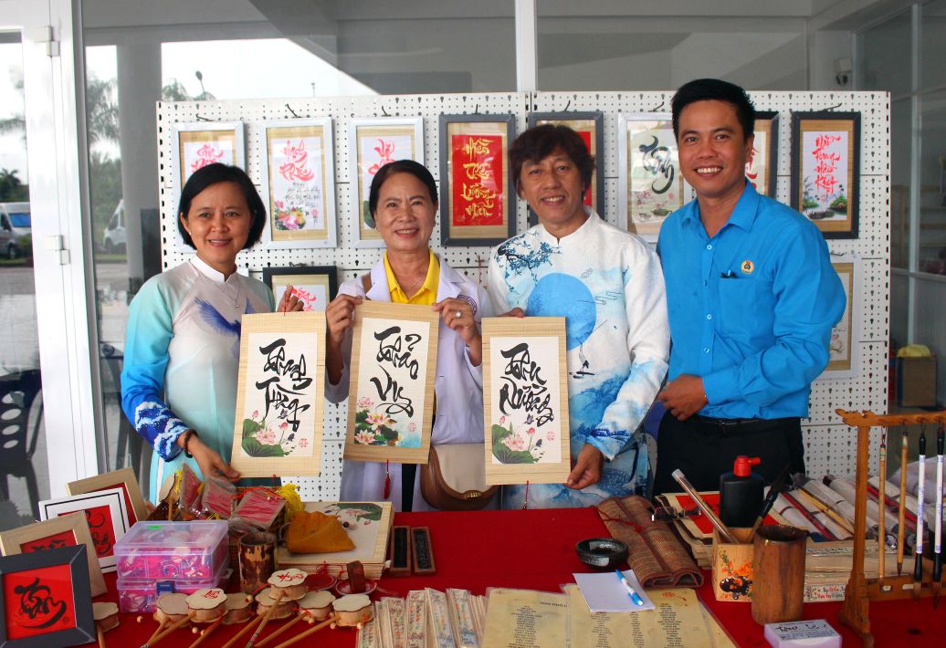 Nhieu nguoi vui ve voi buc thu phap mang ten nguoi than lam qua. Anh: Thanh Mai 