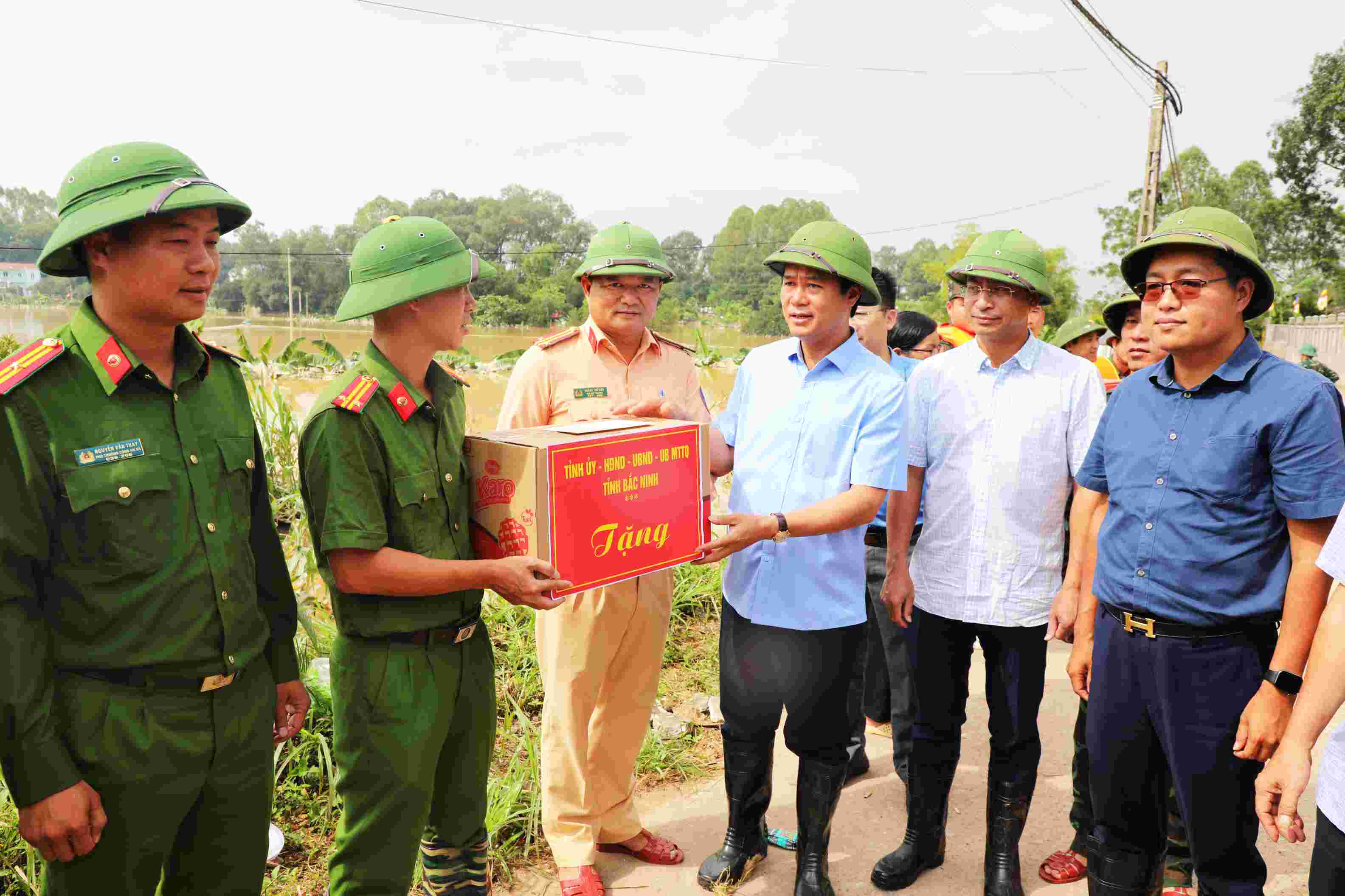 Pho Chu tich UBND tinh Bac Ninh Le Xuan Loi (thu 2 ben phai) tang qua dong vien can bo, chien sy luc luong vu trang tham gia phong chong, khac phuc hau qua cua mua lu tai xa Tien Luc ngay 11.10. Anh: Huu Thang  