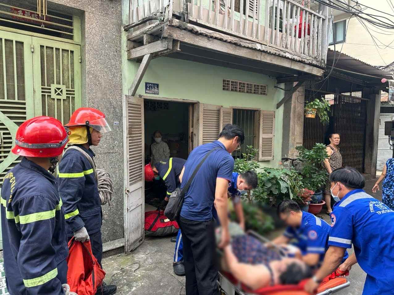 Hinh anh nguoi phu nu duoc cac chien si PCCC dua ra ngoai va ban giao cho y te. Anh: Cong an cung cap