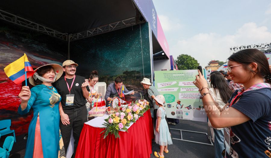 Des touristes prennent des photos souvenirs au stand de la Colombie. Photo : Hai Nguyen