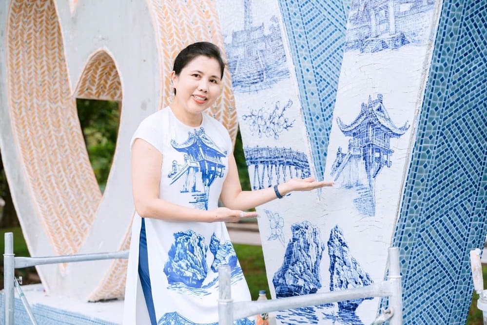 화가 Thu Thuy가 작품 Trai tim Tinh yeu Viet Nam 옆에 서 있습니다. 사진: 캐릭터 제공