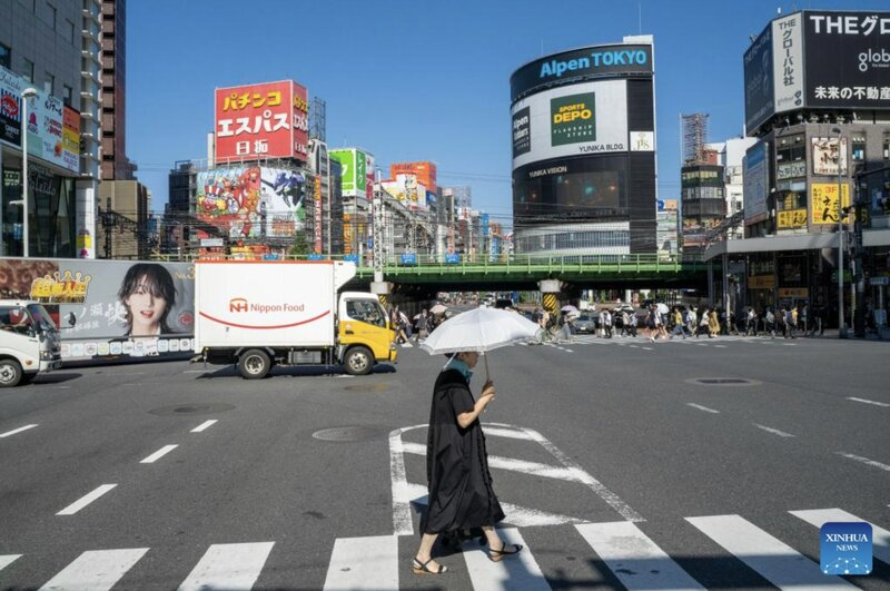 Hot weather makes Japanese men prefer to use umbrellas to shield themselves from the sun, an action that is considered reserved for women. Photo: Xinhua