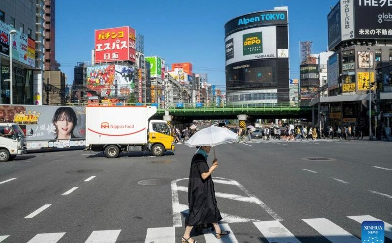 Hot weather makes Japanese men prefer to use umbrellas to shield themselves from the sun, an action that is considered reserved for women. Photo: Xinhua