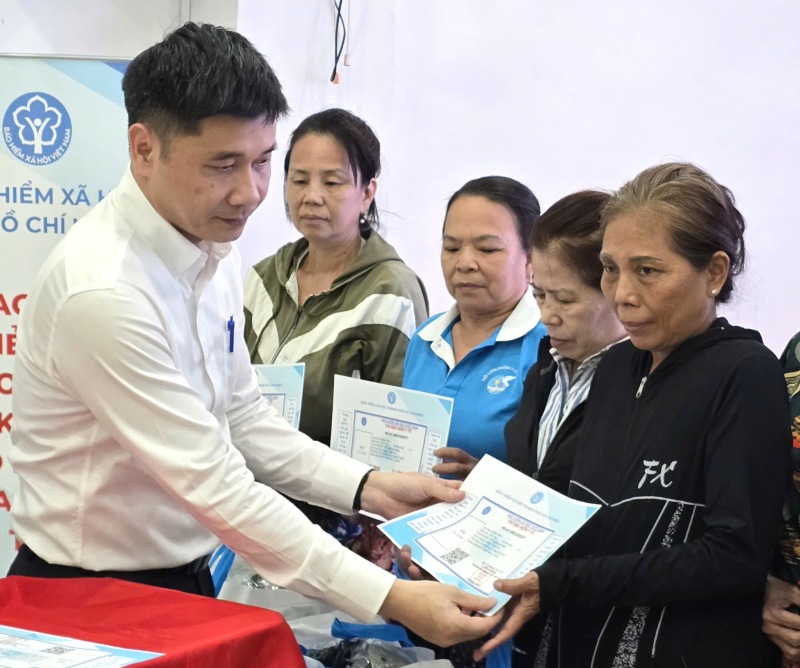 호치민시 사회 보험 부국장 Tran Dung Ha 씨가 어려운 환경에 처한 여성들에게 건강 보험 카드를 선물하고 있습니다. 사진: Nam Duong