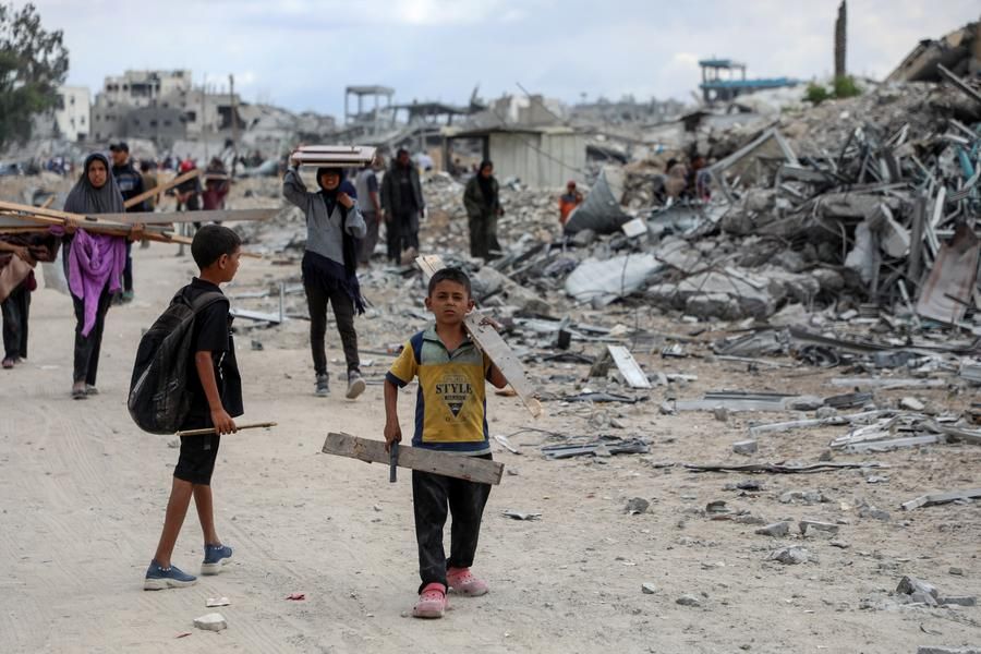 Palestinians pass the rubble in Khan Younis, southern Gaza Strip, after returning home on October 12, 2025. Photo: Xinhua