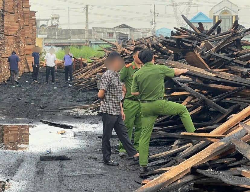 Cơ quan chức năng đang khám nghiệm điều tra làm rõ nguyên nhân vụ cháy công ty gỗ ở phường Tân Hiệp, TPHCM. Ảnh: Đình Trọng