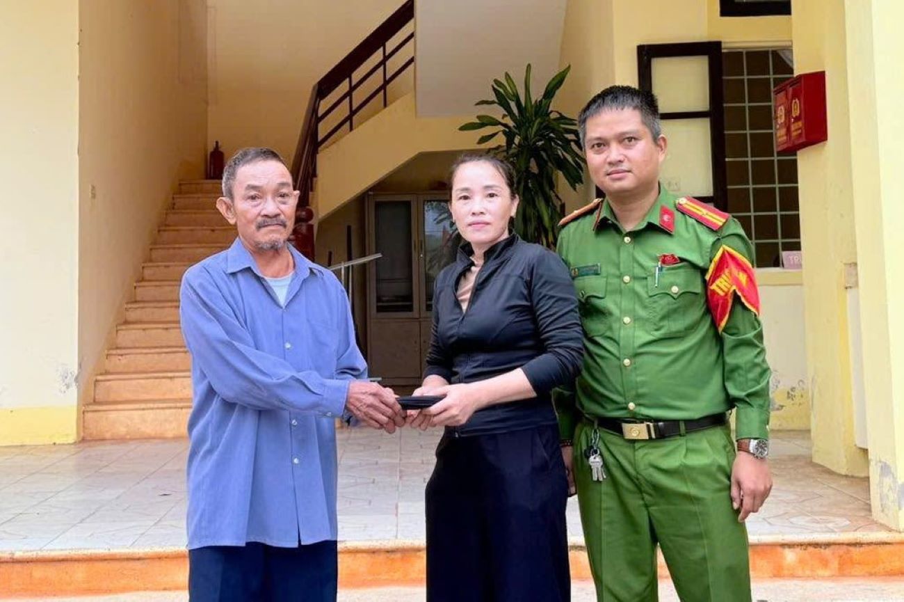 El Sr. Hoang Van Dung devuelve el dinero y el oro recogidos a la mujer. Foto: Policia de la comuna de Ben Quan