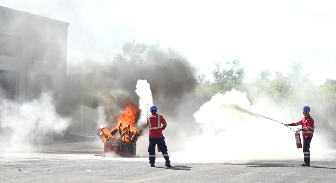Workers practice fire fighting.