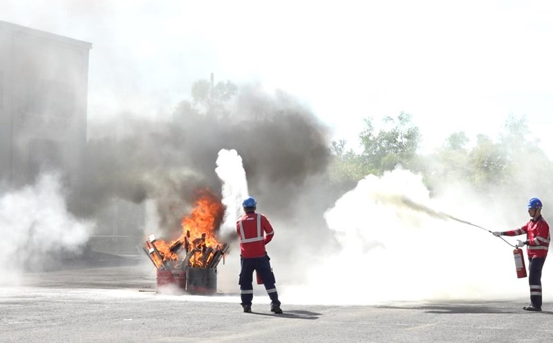 Workers practice fire fighting.