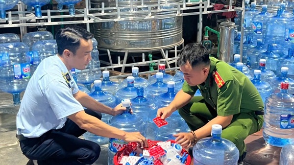 La police de Hanoï arrete un groupe de personnes vendant sur le marche 20 000 bouteilles de Lavie contrefaites. Photo : CAHN