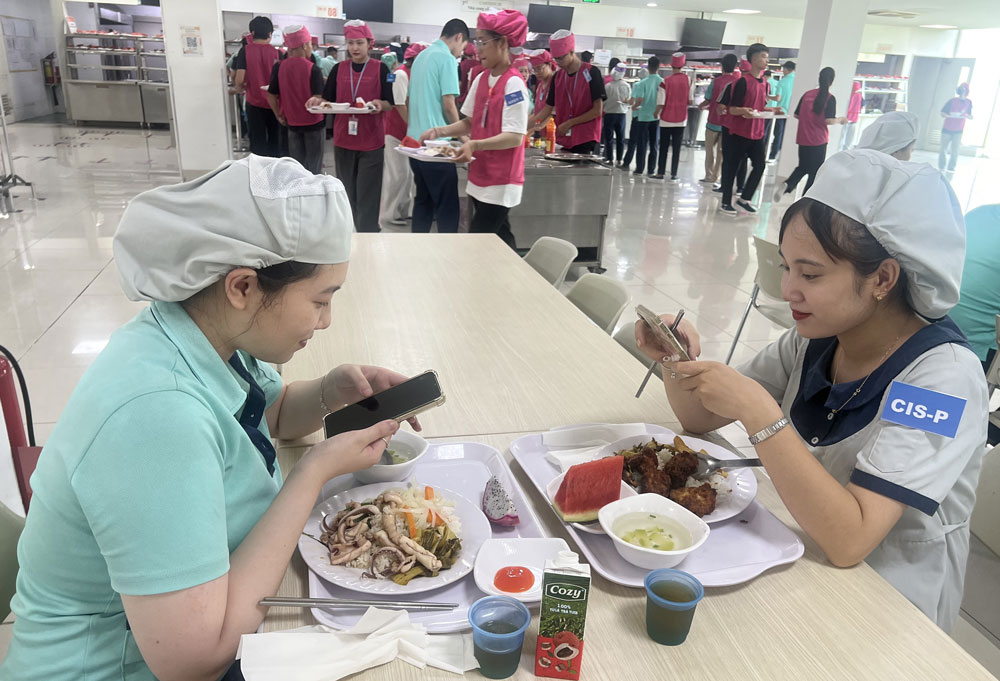 Cong nhan Cong ty TNHH Canon Viet Nam chup anh suat an tai Bua com Cong doan de chia se voi ban be va nguoi than. Anh: KIEU VU