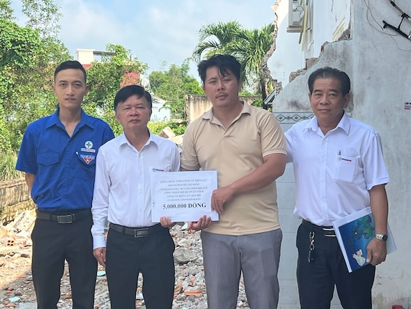 ダットド電力労働組合委員長のレ・ミン・チュオン氏（左から2人目）が、竜巻により家が甚大な被害を受け、屋根が吹き飛ばされ、壁が倒壊した送電網運用管理チームの職員グエン・ディン・カイン氏の家族を訪問し、支援を行った。写真: ゴック・ミン