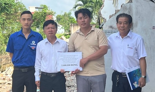 Ông Lê Minh Trưởng – Chủ tịch Công đoàn Công ty Điện lực Đất Đỏ (thứ 2 từ trái qua) thăm và trao hỗ trợ cho gia đình anh Nguyễn Đình Khanh – người lao động thuộc Đội quản lý vận hành lưới điện, có nhà bị thiệt hại nặng do mưa lốc, tốc mái và sập vách. Ảnh: Ngọc Minh