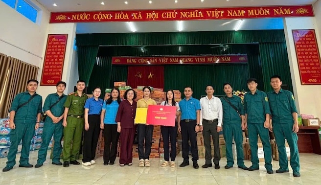 Le representant du syndicat du quartier de Cau Giay et la delegation de travail remettent des cadeaux aux habitants des communes de Trung Gia et Da Phuc. Photo : Phuong Linh