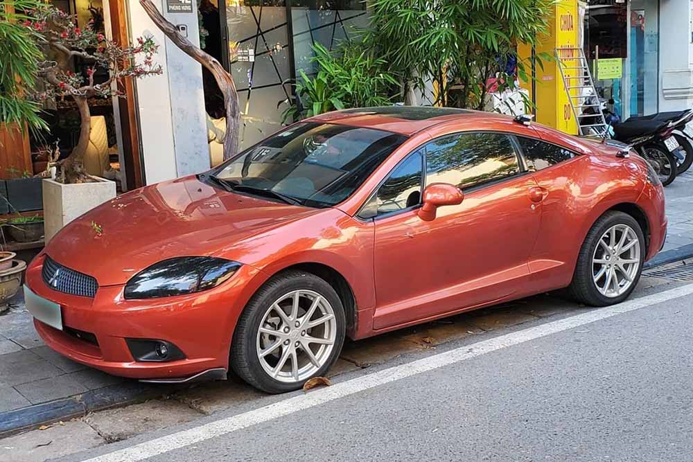 El Mitsubishi Eclipse coupe naranja con forma de cuervo destaca en las calles de Hanoi atrayendo la atencion gracias a su diseño deportivo y las ventanas al aire libre. Foto: Bao Quoc