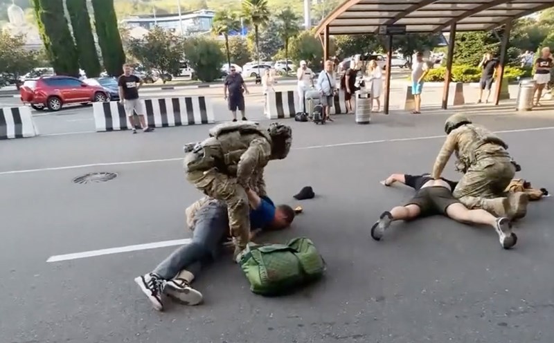 Russian law enforcement officers are suppressing the suspect. Photo cut from video of the Russian Ministry of Home Affairs