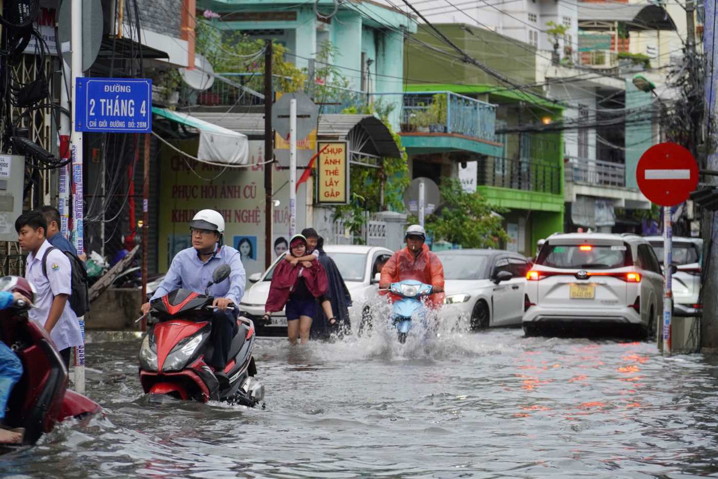 Nhieu phu huynh phai cong con ve som khi duong 2/4 ngap len cao. Anh: Huu Long