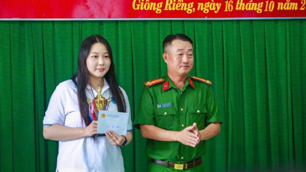 Lieutenant Colonel Vo Thanh Nhan, Head of Giong Rieng Commune Police, presented the first prize to Nguyen Thi Thi Hoa. Photo: Thanh Chien