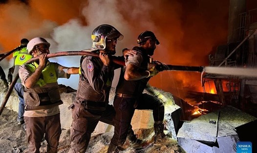 Người dân nỗ lực dập tắt đám cháy tại một nhà máy xi măng ở Ansar, miền nam Lebanon, sau cuộc không kích của Israel ngày 16.10. Ảnh: Xinhua