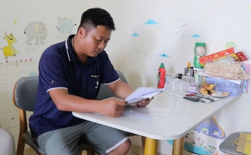 Mr. Tran Gia Tan is referring to the documents and conditions for buying social housing. Photo: Cao Thom
