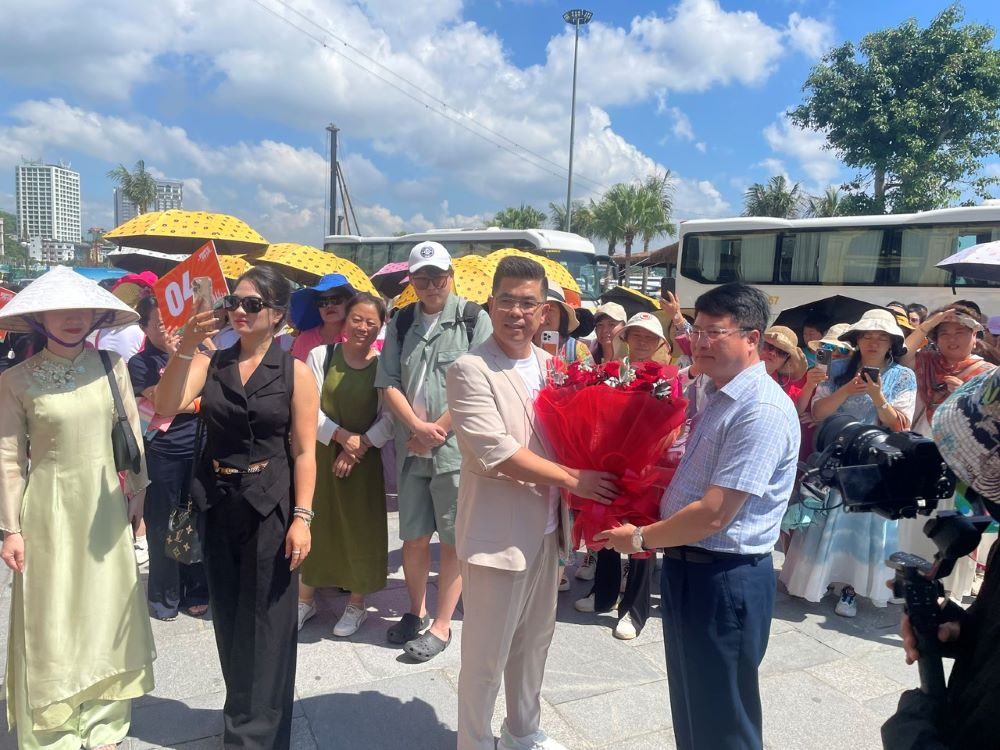 クアンニン省文化スポーツ観光局のリーダーが、2025年10月16日にハロン湾を訪れた約1 000人の中国人観光客の代表団に花を贈呈。写真:グエン・フン