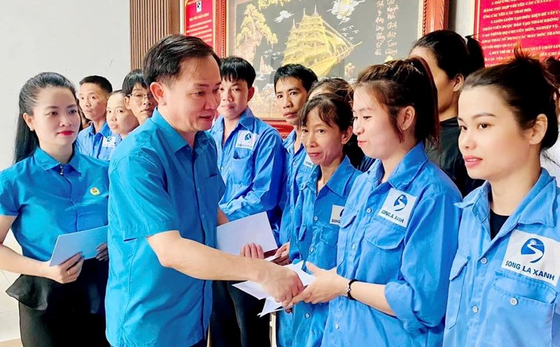 El Sr. Ngo Dinh Van - Vicepresidente de la Federacion Laboral de la provincia de Ha Tinh entrega apoyo para superar las consecuencias de la tormenta numero 10 a los miembros del sindicato de la Compañia Anonima de Papel Song La Xanh. Foto: Mai Anh.