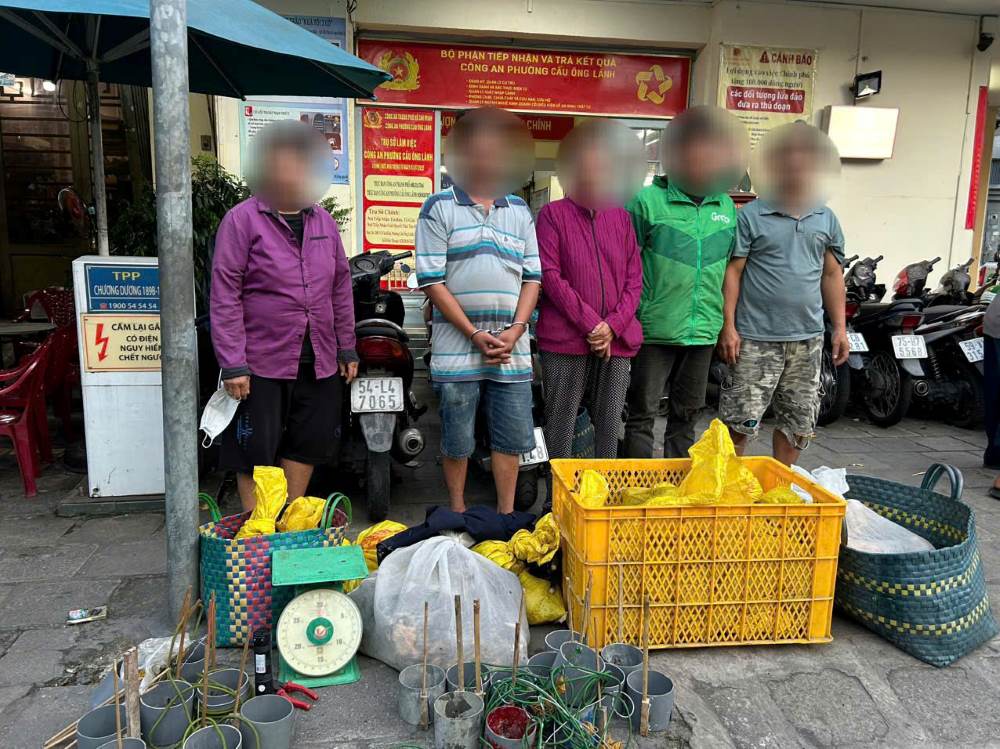 Một số đối tượng bị công an bắt giữ cùng tang vật tại hiện trường để điều tra hành vi tiêu thụ chó mèo trộm cắp. Ảnh: Công an