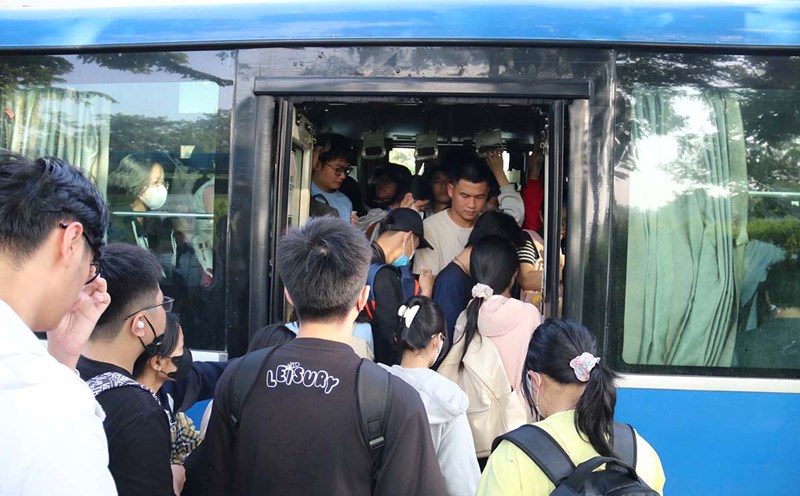 Students jostling in the hot sun, waiting for a bus at Ho Chi Minh City National University Village