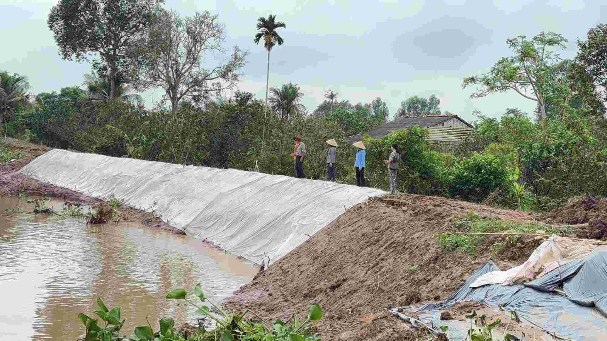 Dap dat, phu mu bac tam thoi de bao ve phan dat bi sat lo la no luc khan cap cua nguoi dan o con Thanh Long. Anh: Hoang Loc