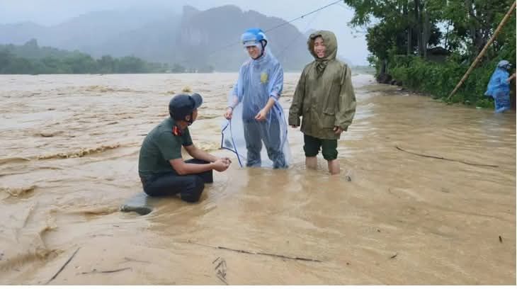 La gente agradece al teniente Luong Duc Suu de la policia de la comuna de Mon Son (Nghe An) por su valiente accion de rescate de personas en medio de las inundaciones. Foto: Ngoc Anh