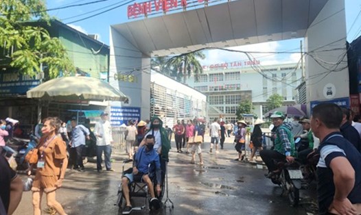 Bệnh nhân bì bõm lội nước bẩn để vào bệnh viện xạ trị. Ảnh: Minh Hạnh