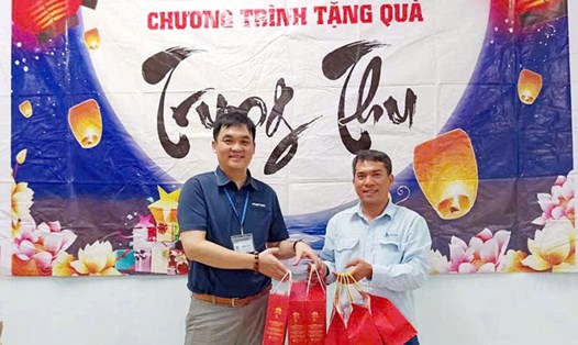 Ông Trần Văn Quang - Chủ tịch Công đoàn cơ sở Công ty TNHH Điện tử Foster Quảng Ngãi (bên trái) - trao quà cho đoàn viên. Ảnh: Xuân Quang